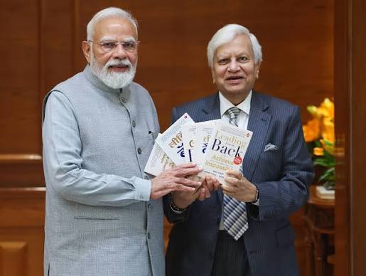 Industry leader Ravi Kant presents his book to PM Modi